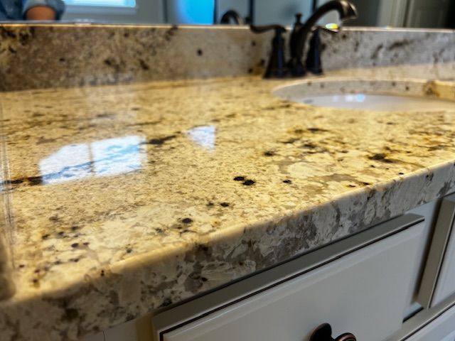Granite bathroom vanity countertop with built-in sink and chrome faucet