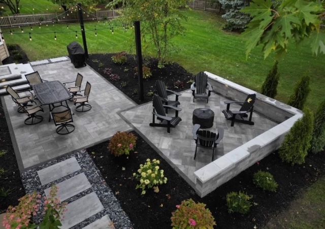Outdoor patio with black furniture, concrete seating area, and landscaped garden path