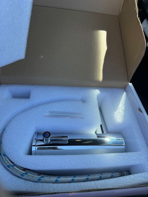Chrome faucet components in a box with white foam padding