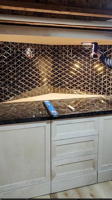 Kitchen countertop with tiled backsplash and a blue remote control on the counter