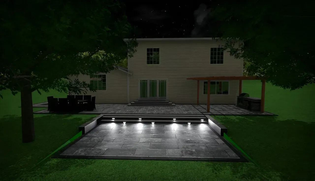 Nighttime house exterior with lit driveway lights and a deck in the backyard