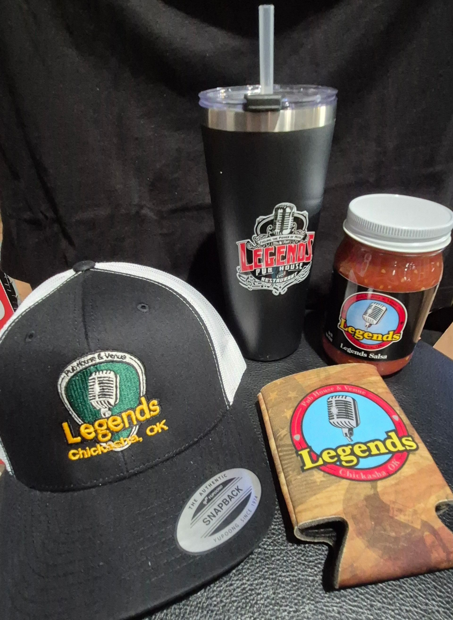 Branded Legends coffee mug, cap, koozie, and jar on a black background