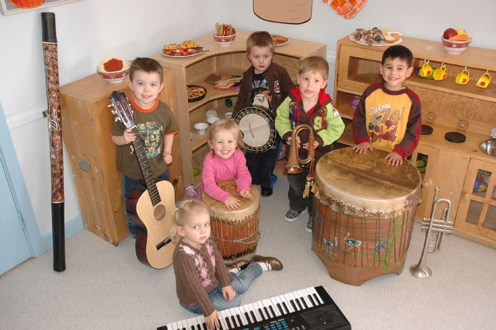 A group of children are playing musical instruments in a room