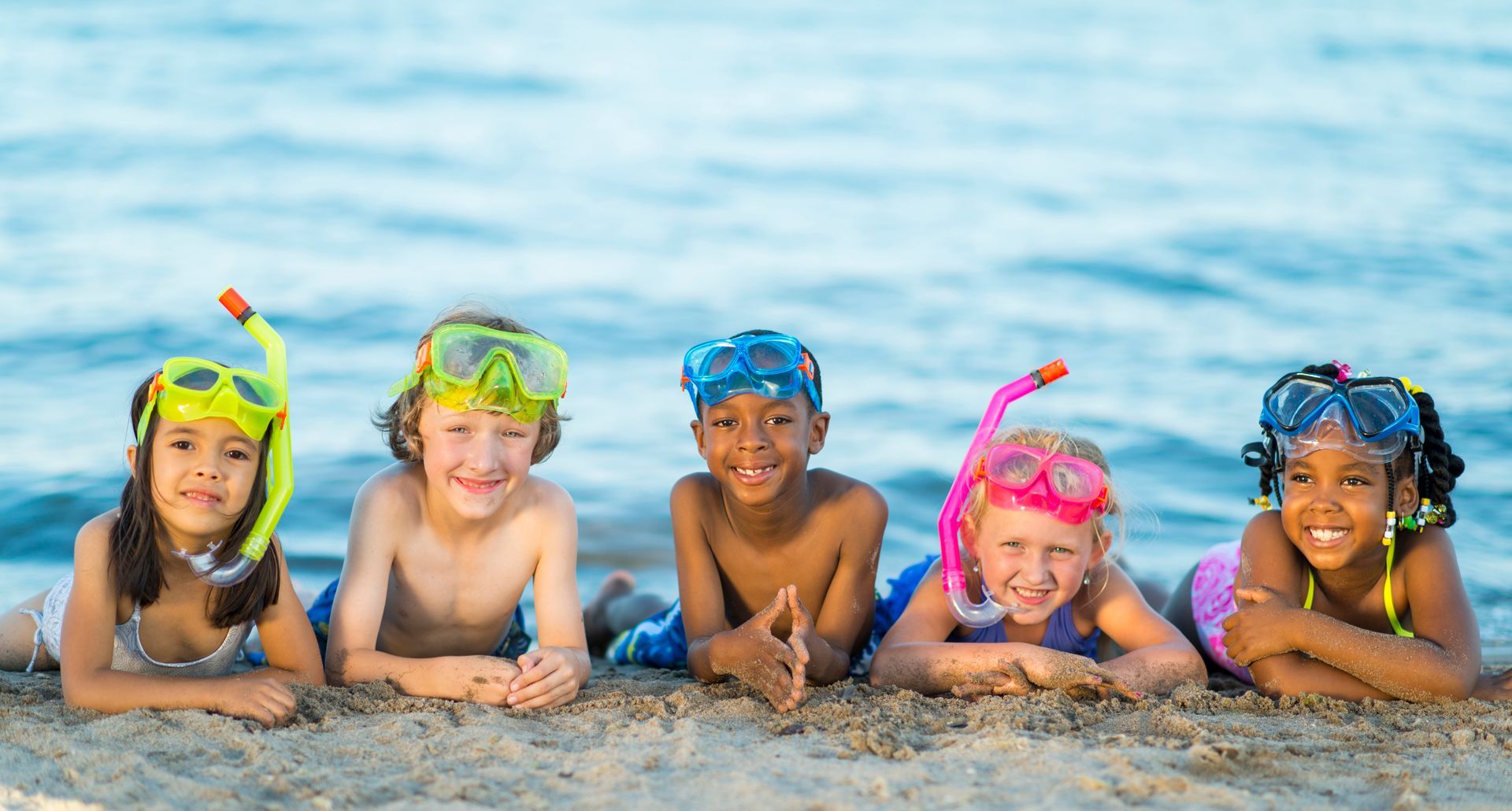 Group of children in a pool wearing goggles and snorkels