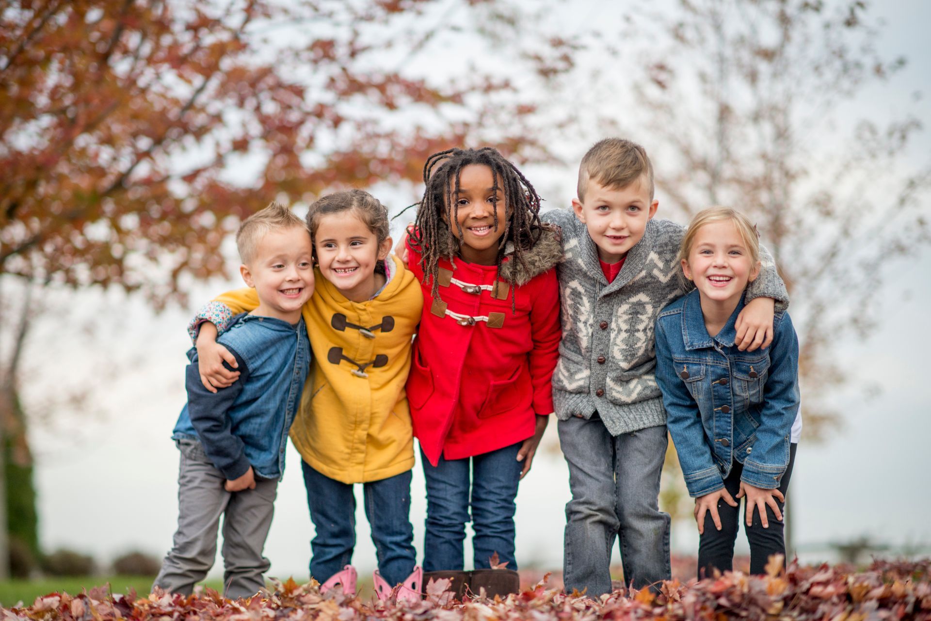 Group of children playing in fall leaves
