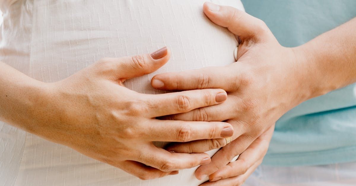 Parents with hands on the mother's baby bump