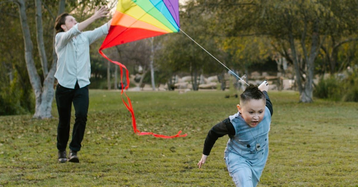 A woman and a child are flying a kite in a park.