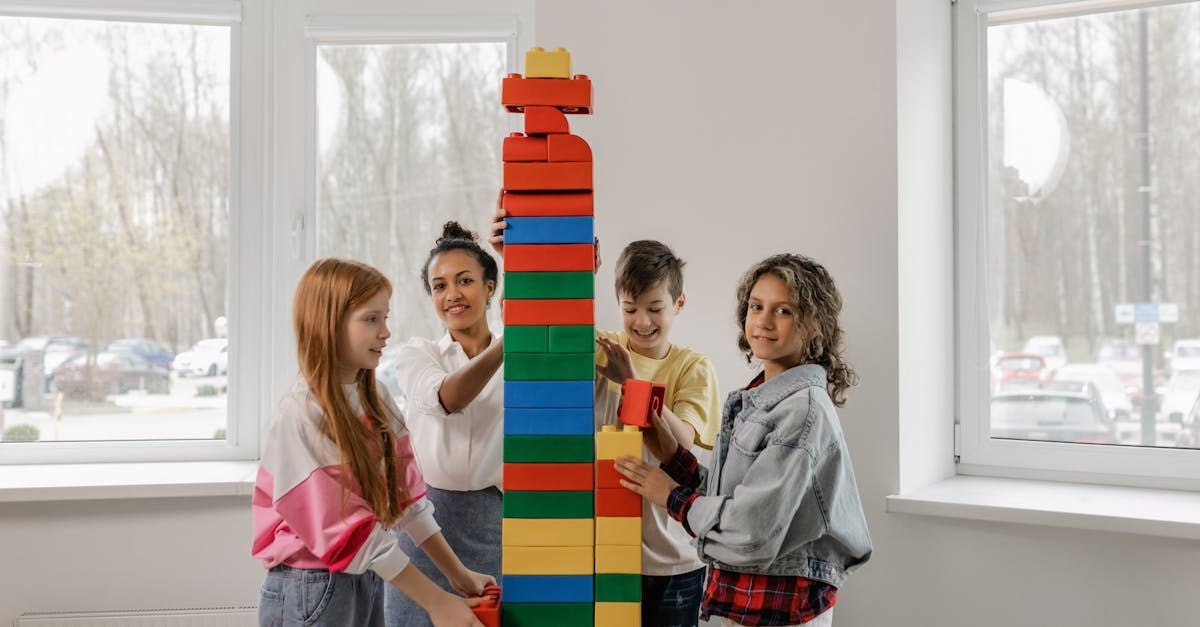 A group of children are building a tower out of lego blocks.