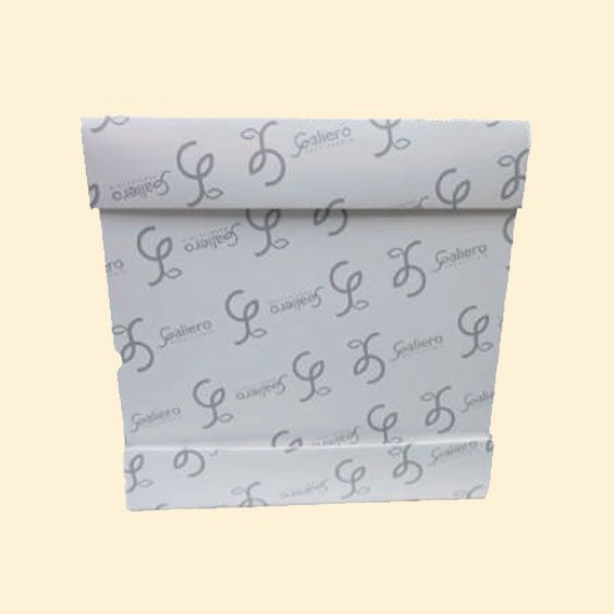Sacchetto di carta bianco piegato con motivi in corsivo grigio su sfondo beige.