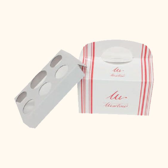 Scatola da forno a righe bianche e rosa con un vassoio di pasticcini rotondi accanto.