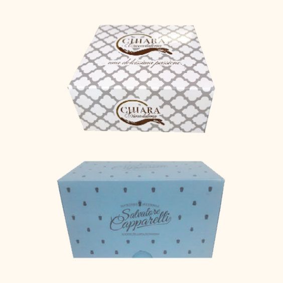 Due scatole regalo decorative, una bianca con griglia grigia e una azzurra a pois.