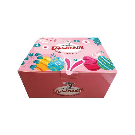Scatola regalo Ferrero Rocher rosa con uova di cioccolato colorate decorate e orecchie di coniglio sulla parte superiore.