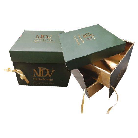 Scatola regalo verde con nastro dorato e coperchio apribile che rivela un interno dorato.
