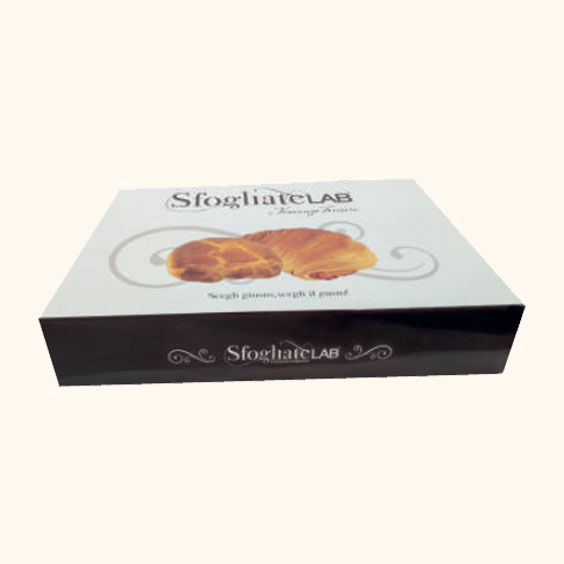 Scatola di sfogliatelle su sfondo chiaro, con un dolce simile a un croissant raffigurato sul coperchio.