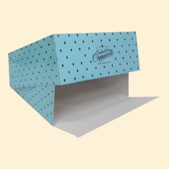 Scatola da forno in cartone a pois blu con aletta interna bianca aperta su sfondo beige.