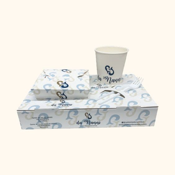 Scatola regalo e tazza bianche con logo, decorate con motivi a spirale blu su sfondo chiaro.