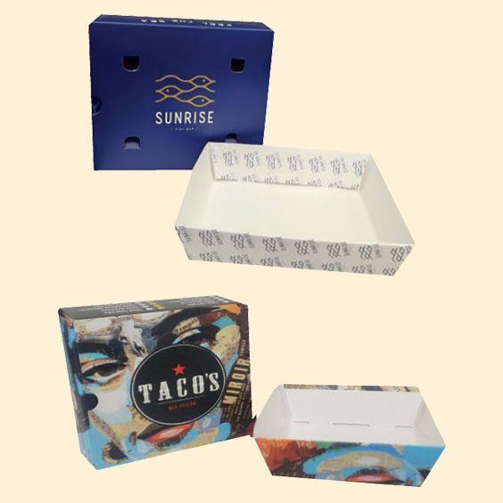 Quattro scatole di cartone personalizzate con disegni blu, bianchi e multicolore su sfondo chiaro.