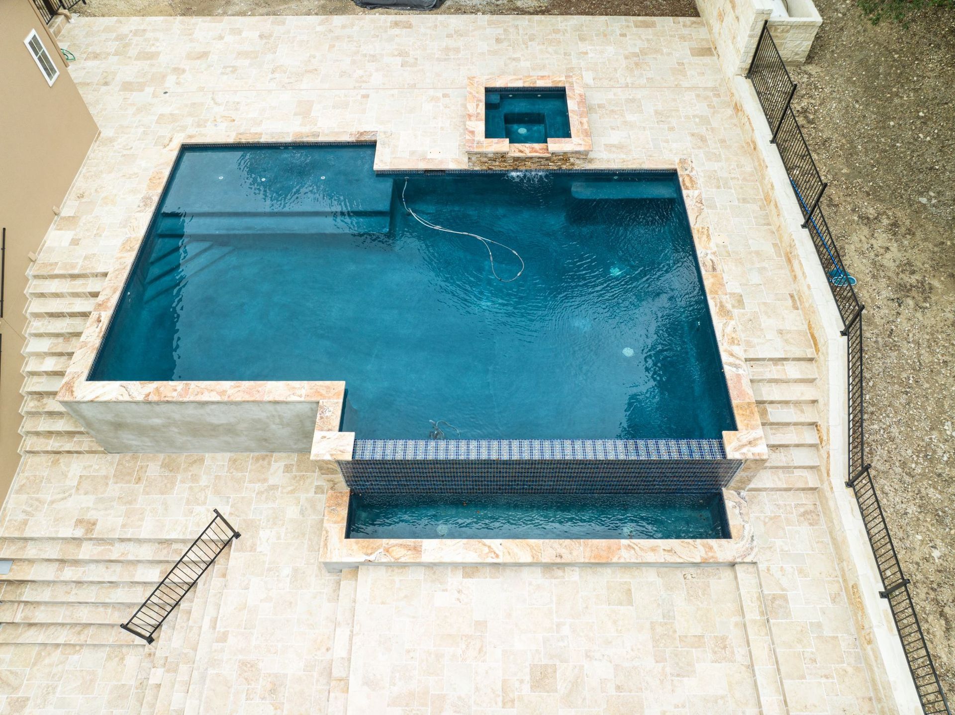 An aerial view of a large swimming pool designed by Fine Patio Design San Antonio TX