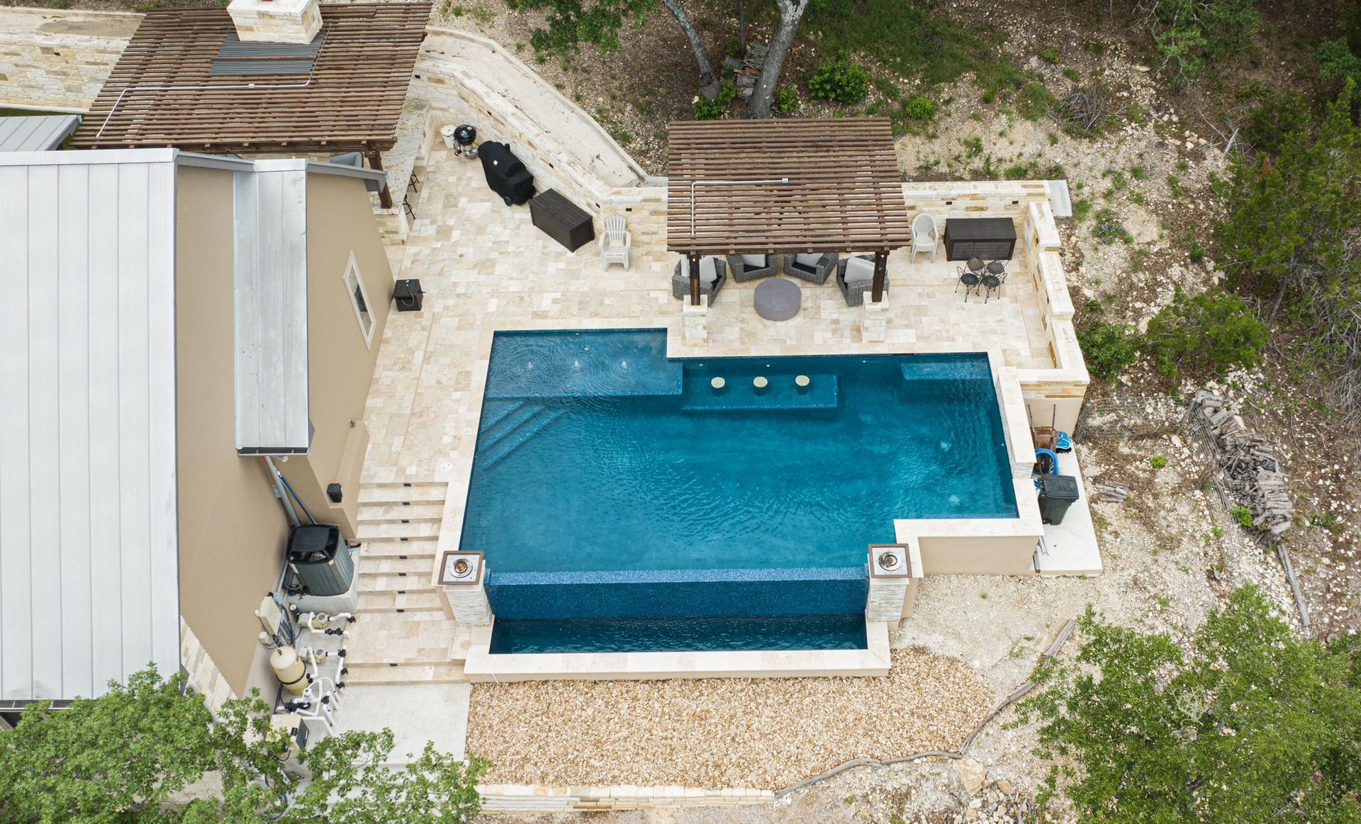 An aerial view of a house with a large swimming pool designed by Fine Patio Design San Antonio TX