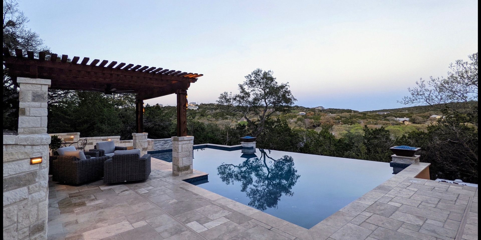 A large swimming pool with a pergola over it built by Fine Patio Design San Antonio TX