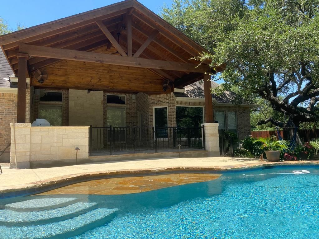 A house with a large swimming pool in front of it built by Fine Patio Design San Antonio TX