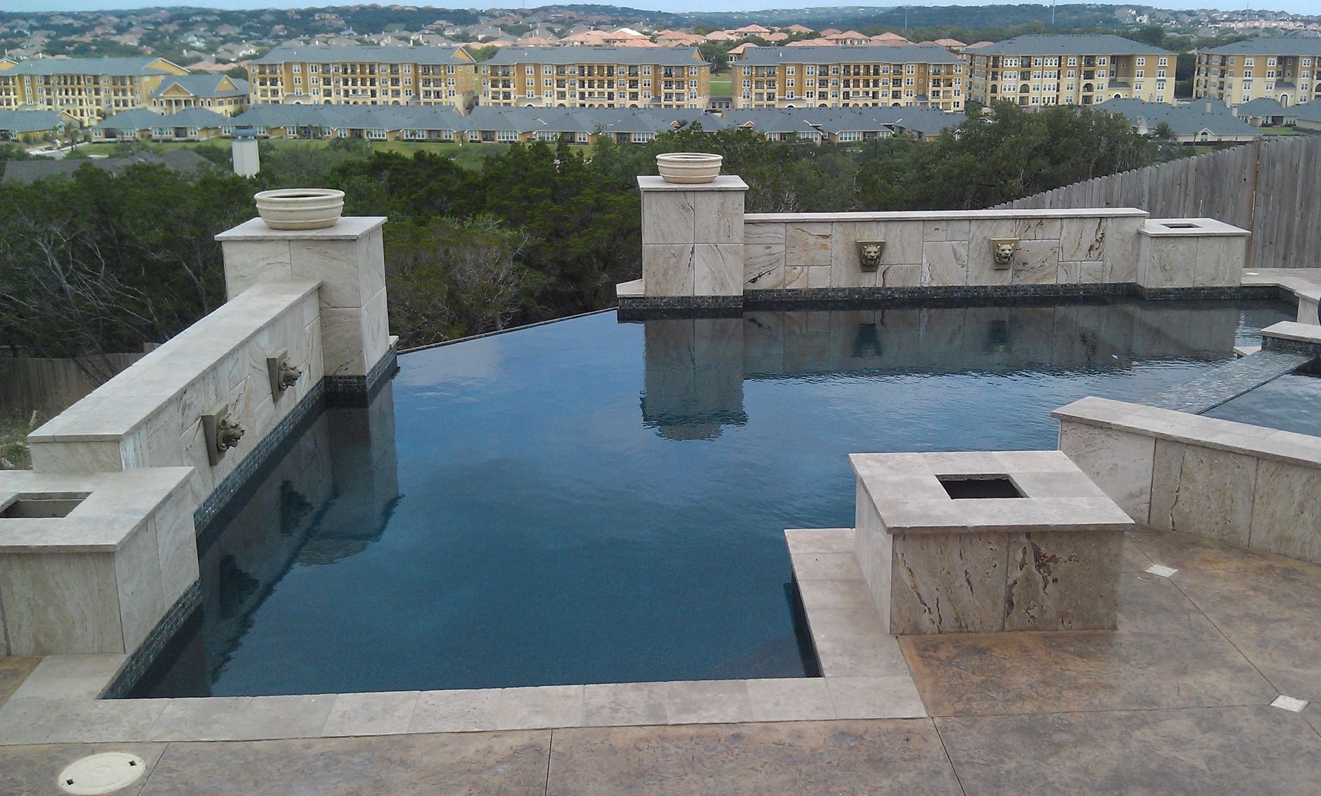 A swimming pool with a view of a city in the background built by Fine Patio Design San Antonio TX