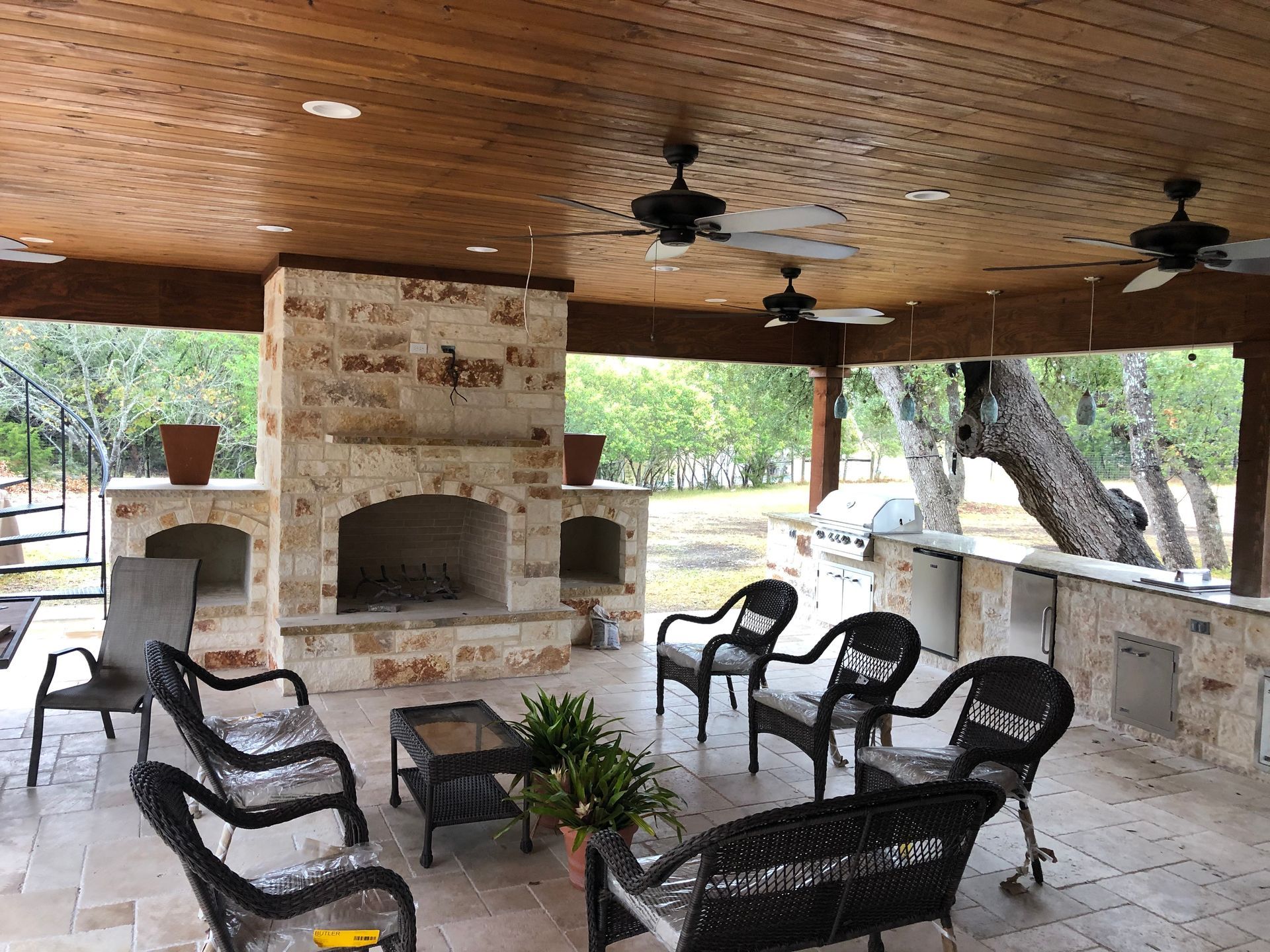 A patio with wicker chairs and a fireplace built by Fine Patio Design San Antonio TX