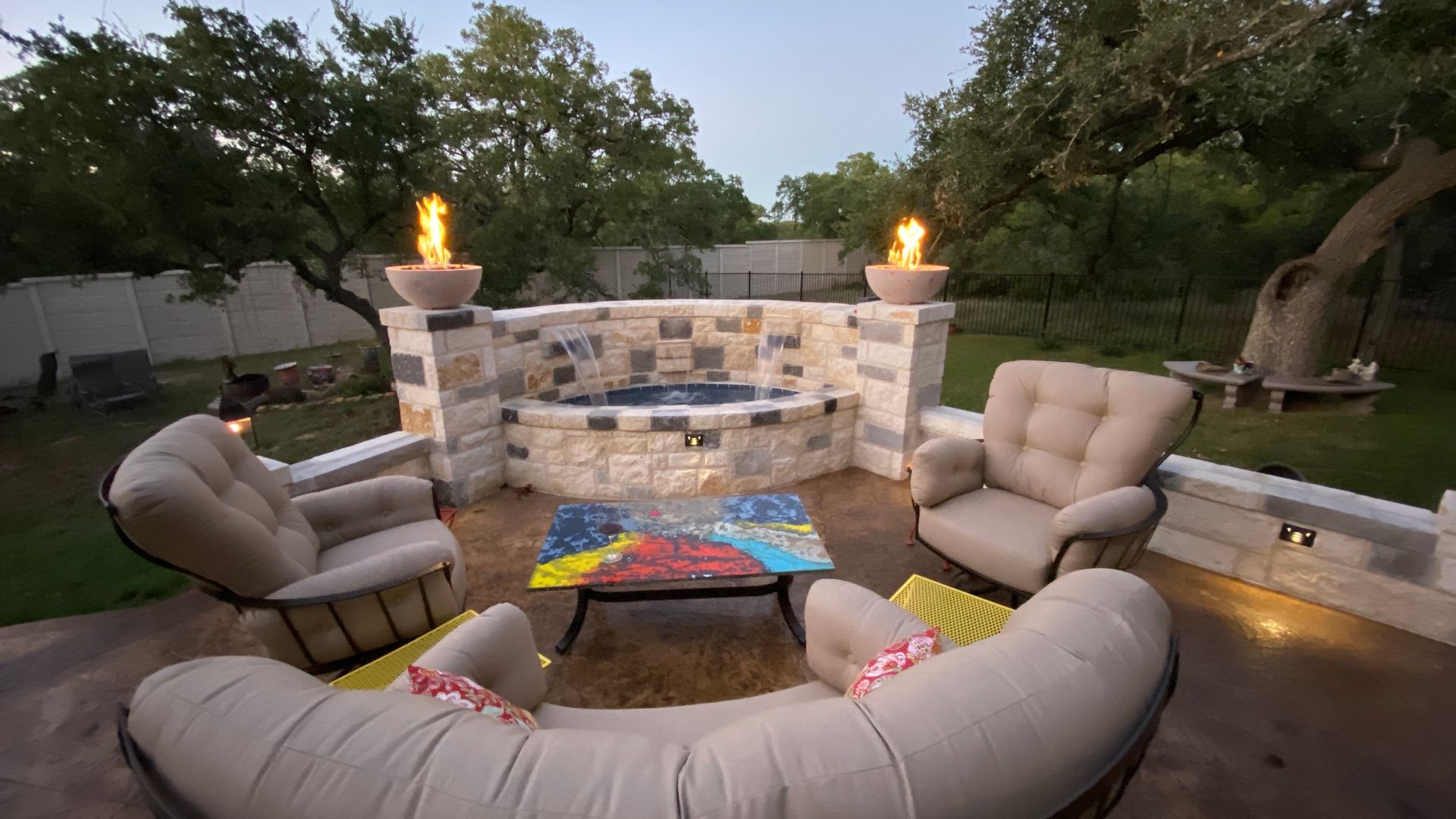 A patio area with a couch and chairs and a fire pit built by Fine Patio Design San Antonio TX 