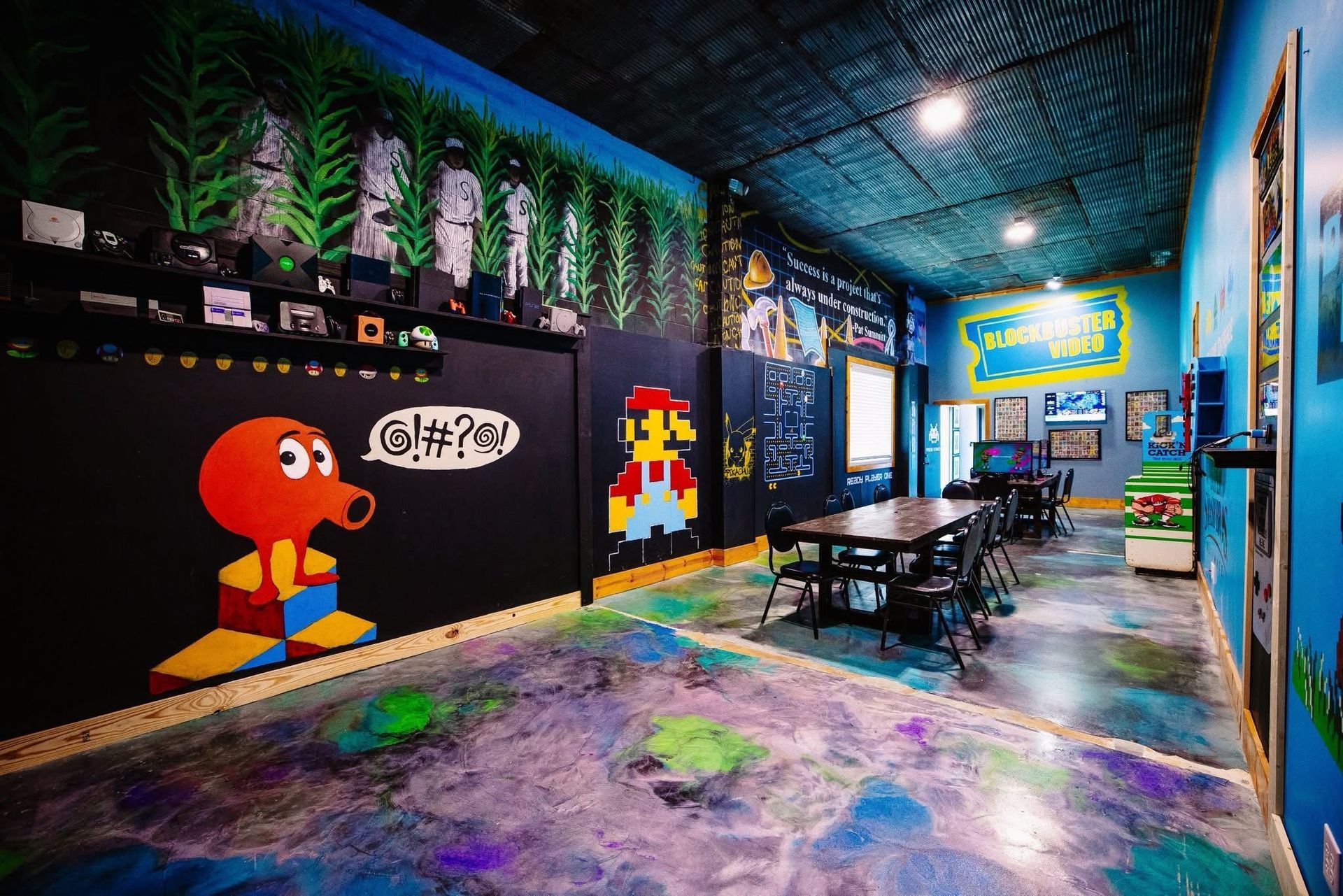 Colorful graffiti-covered indoor café with tables, chairs, and neon-lit walls