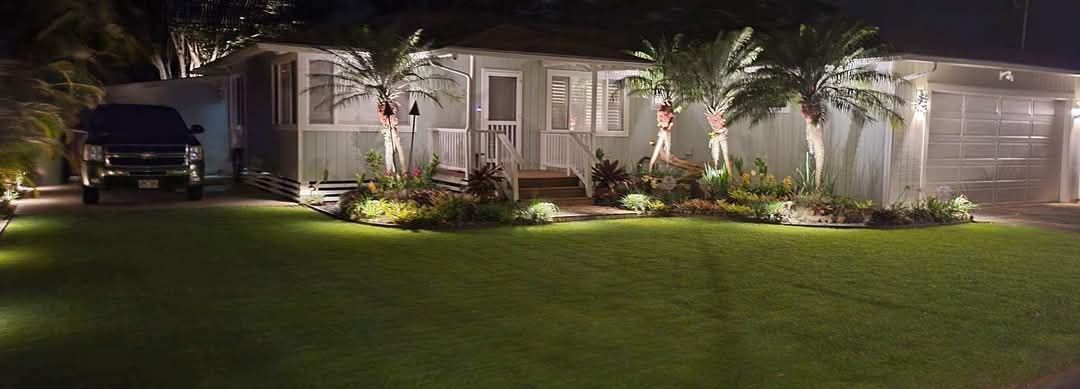 A large house with a lush green lawn and patio area in front of it.