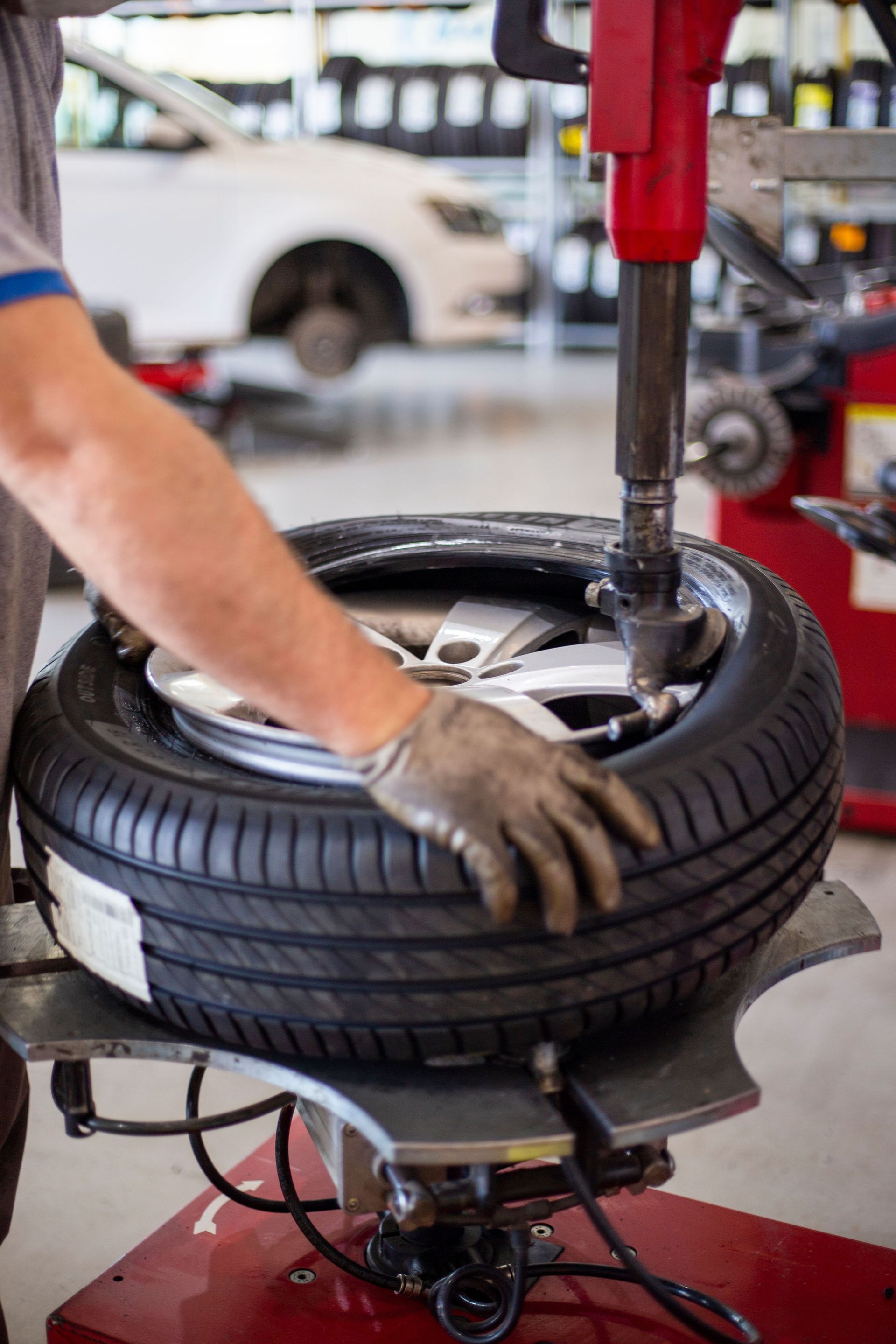 Mechanic using a tire-changing machine to mount a tire in an auto shop
