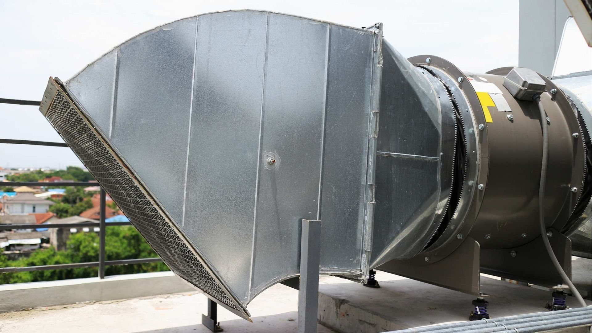 A large metal pipe is sitting on top of a building.