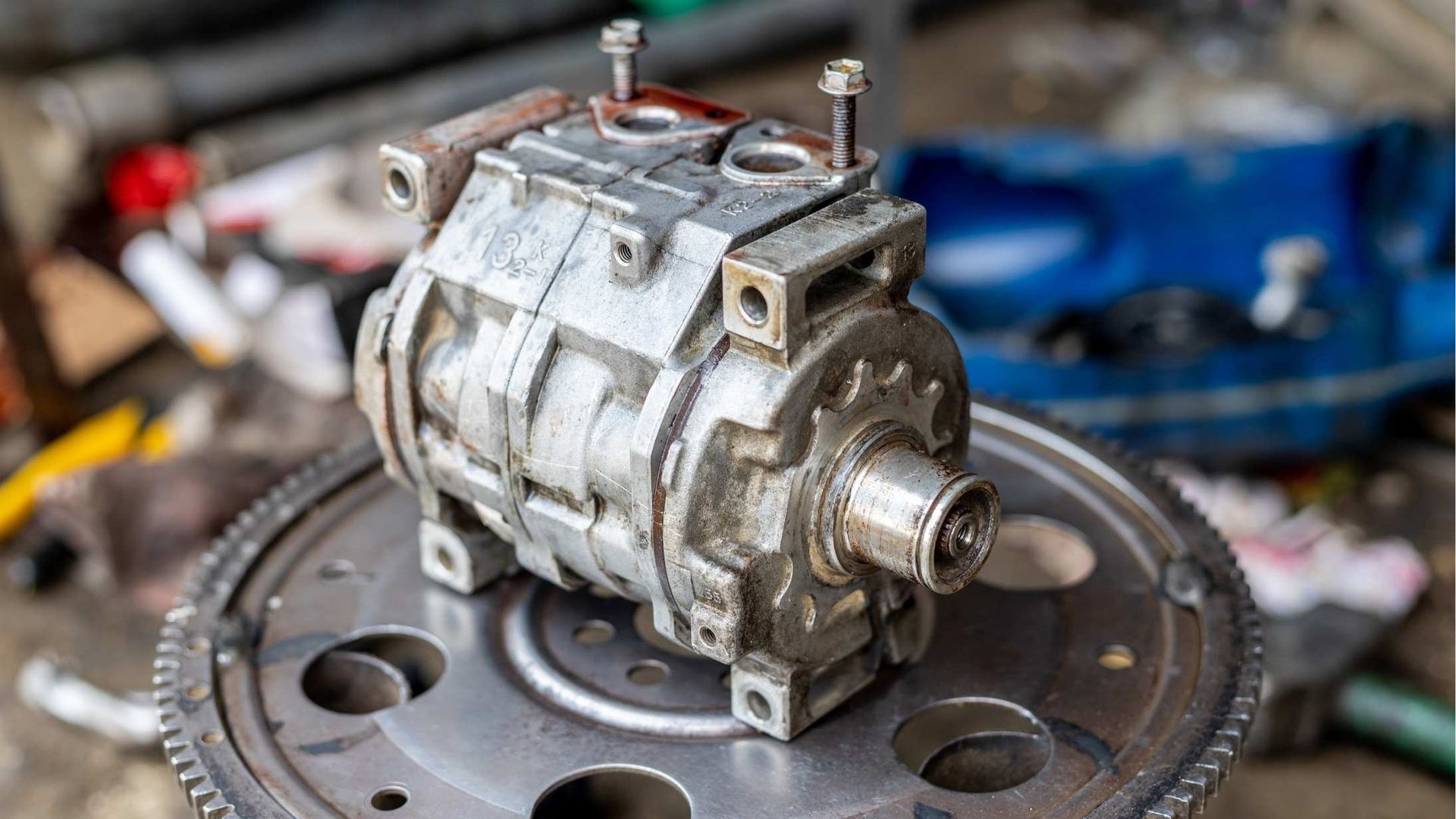 An air conditioner compressor is sitting on top of a gear.