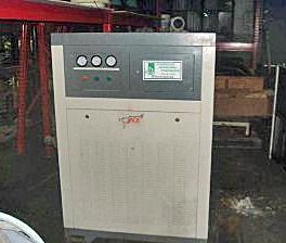 A large white and gray machine is sitting in a warehouse.