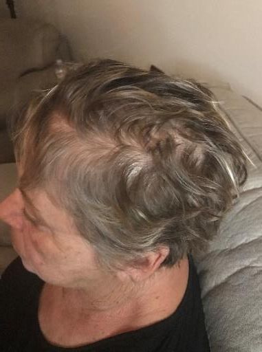 A woman with gray hair is sitting on a couch