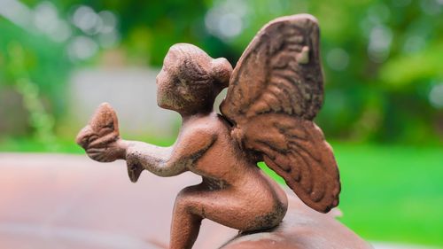 Small ceramic human figurine with butterfly wings, used to decorate a garden