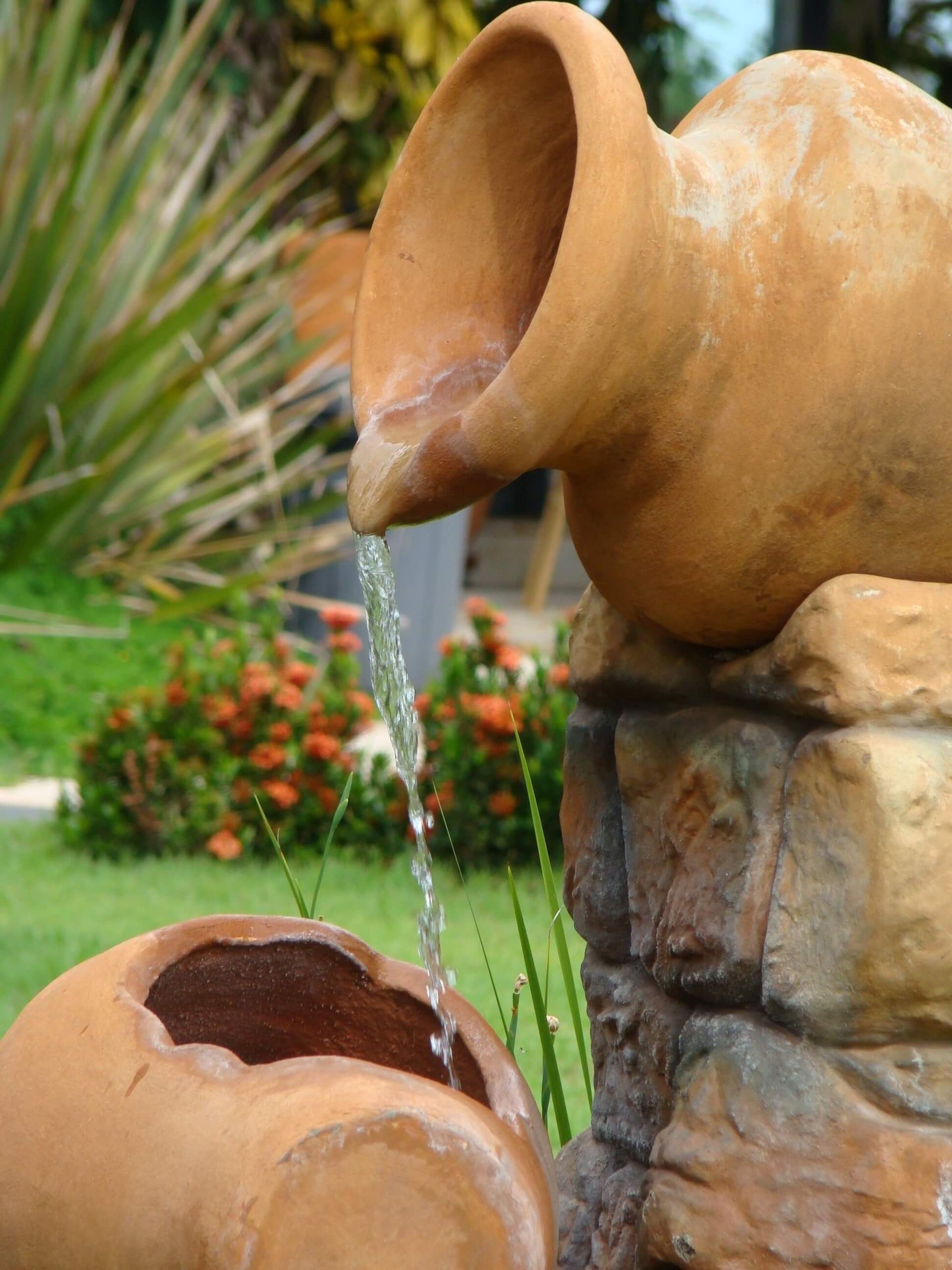 Water fountain created from clay pots, one tilted with water flowing down into the other clay pot