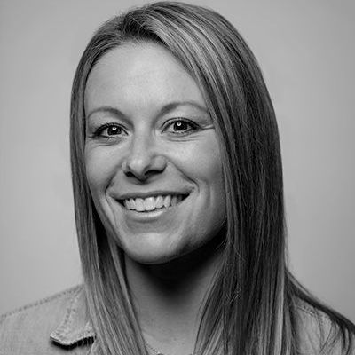 A woman is smiling in a black and white photo.