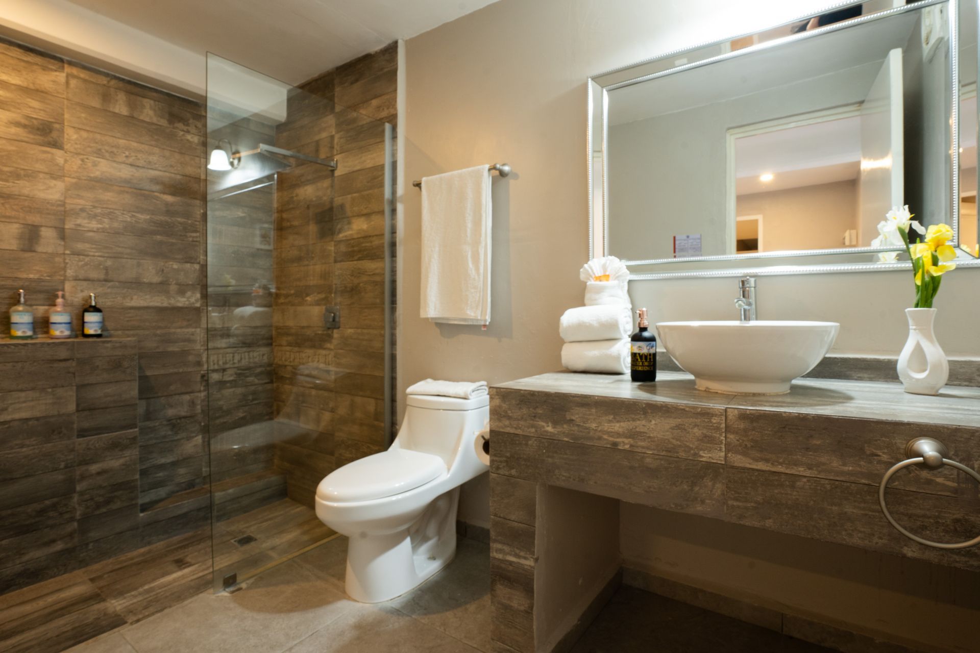 Baño moderno con ducha con azulejos de piedra, tocador e inodoro.
