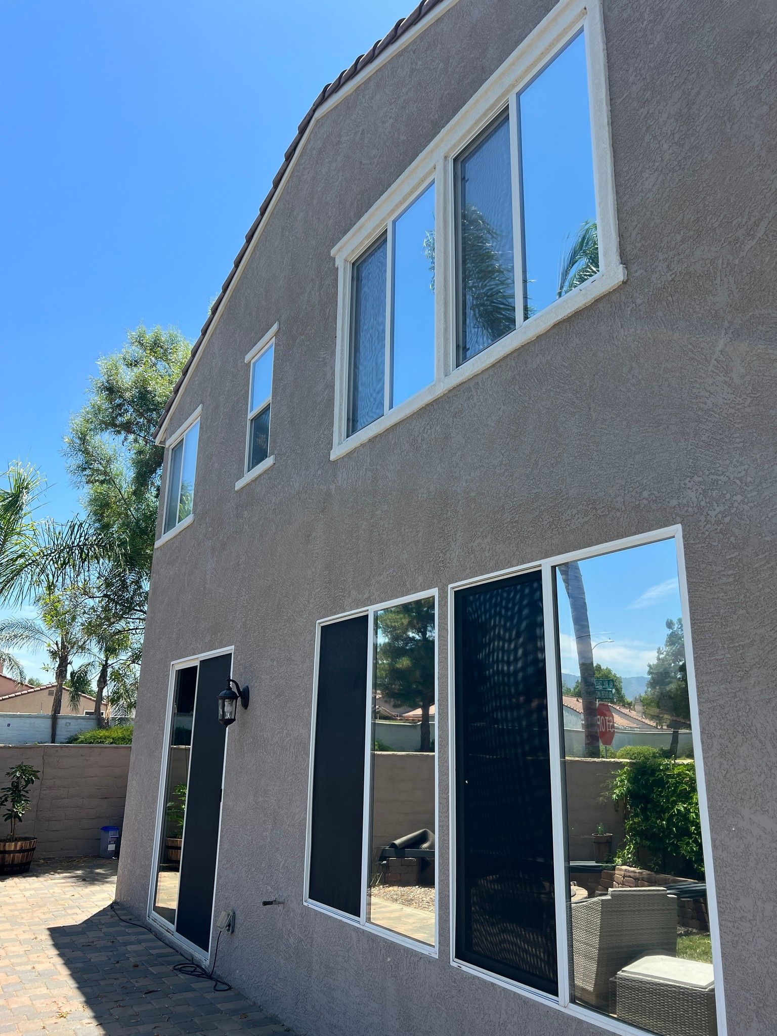 A house with a lot of windows and a blue sky in the background