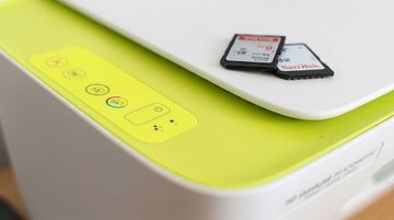 Primo piano di un dispositivo bianco con un pannello verde lime e due schede di memoria sulla parte superiore.