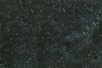 Dark, grainy textured surface with mottled gray-green speckles
