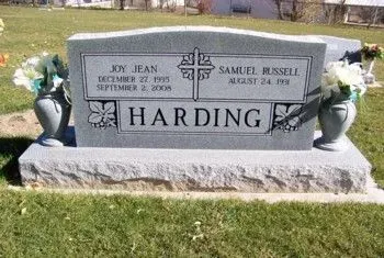 Gray granite Hardin family gravestone with flowers, set on grass in a cemetery.