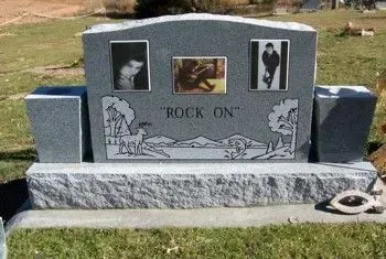 Gray granite pet memorial with three framed pet photos and the words “ROCK ON” in a grassy yard