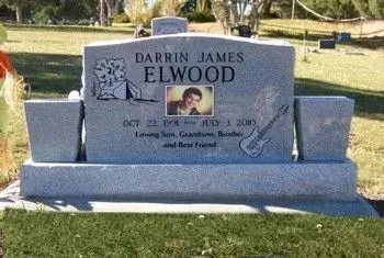 Gray granite gravestone for Darrin James Elwood in a grassy cemetery