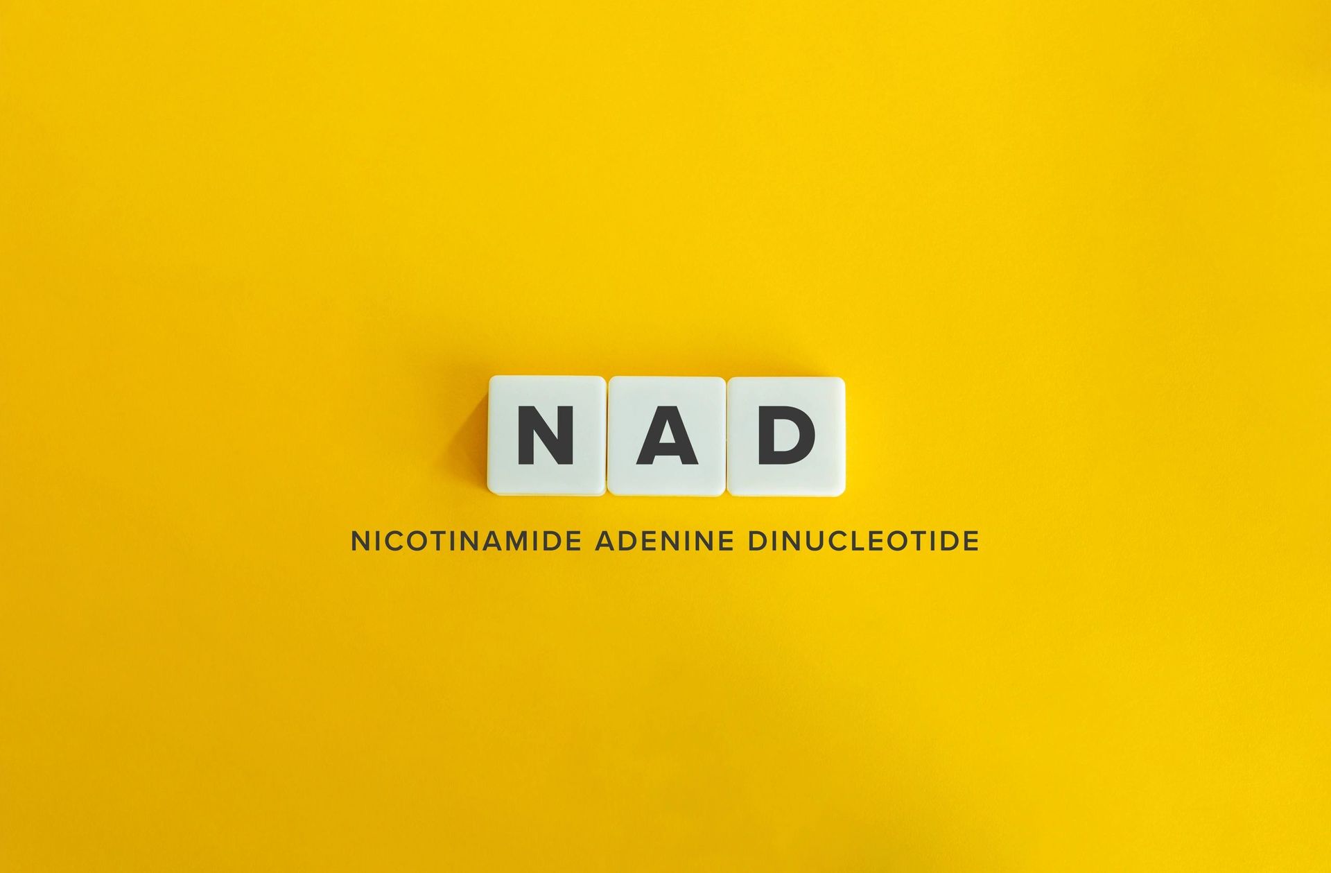 The word nad is written in blocks on a yellow background.