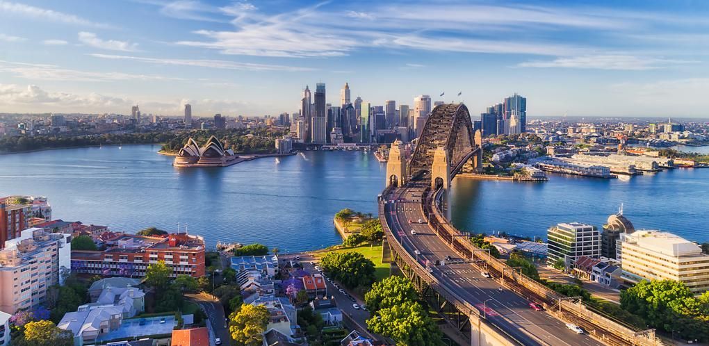 Aerial view of the Harbour Bridge with the city skyline across the blue water.