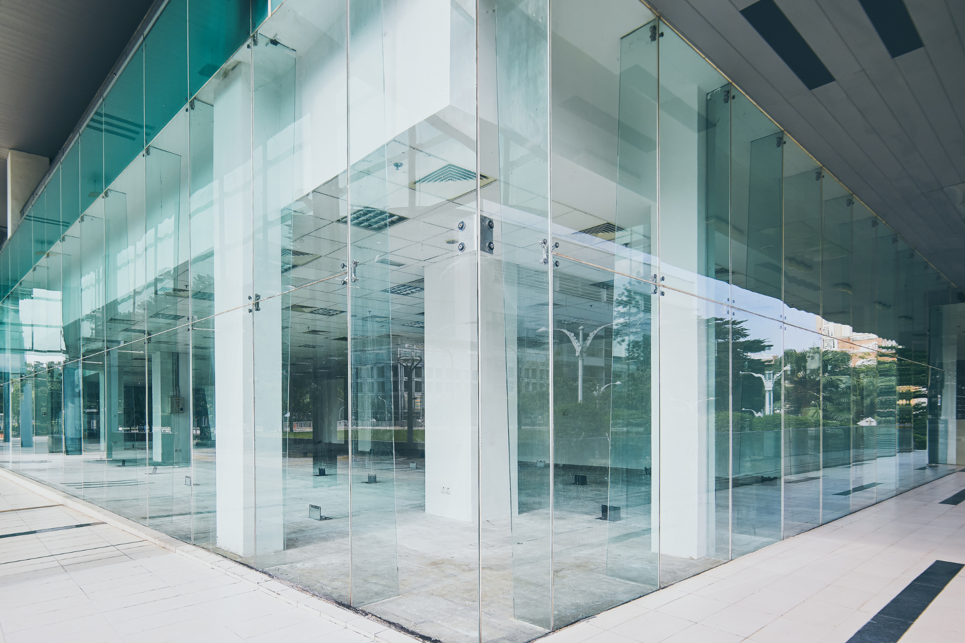 Modern building with glass walls and white pillars.