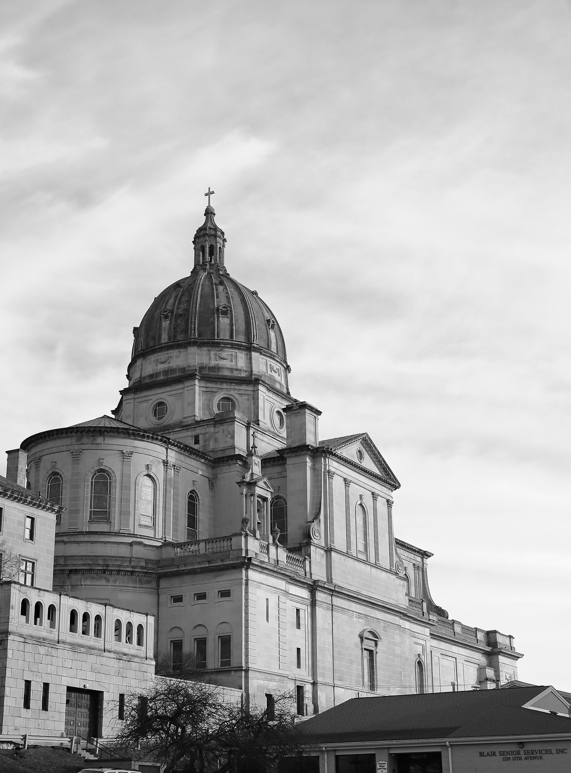 Large domed stone cathedral against a cloudy sky, viewed from below.
