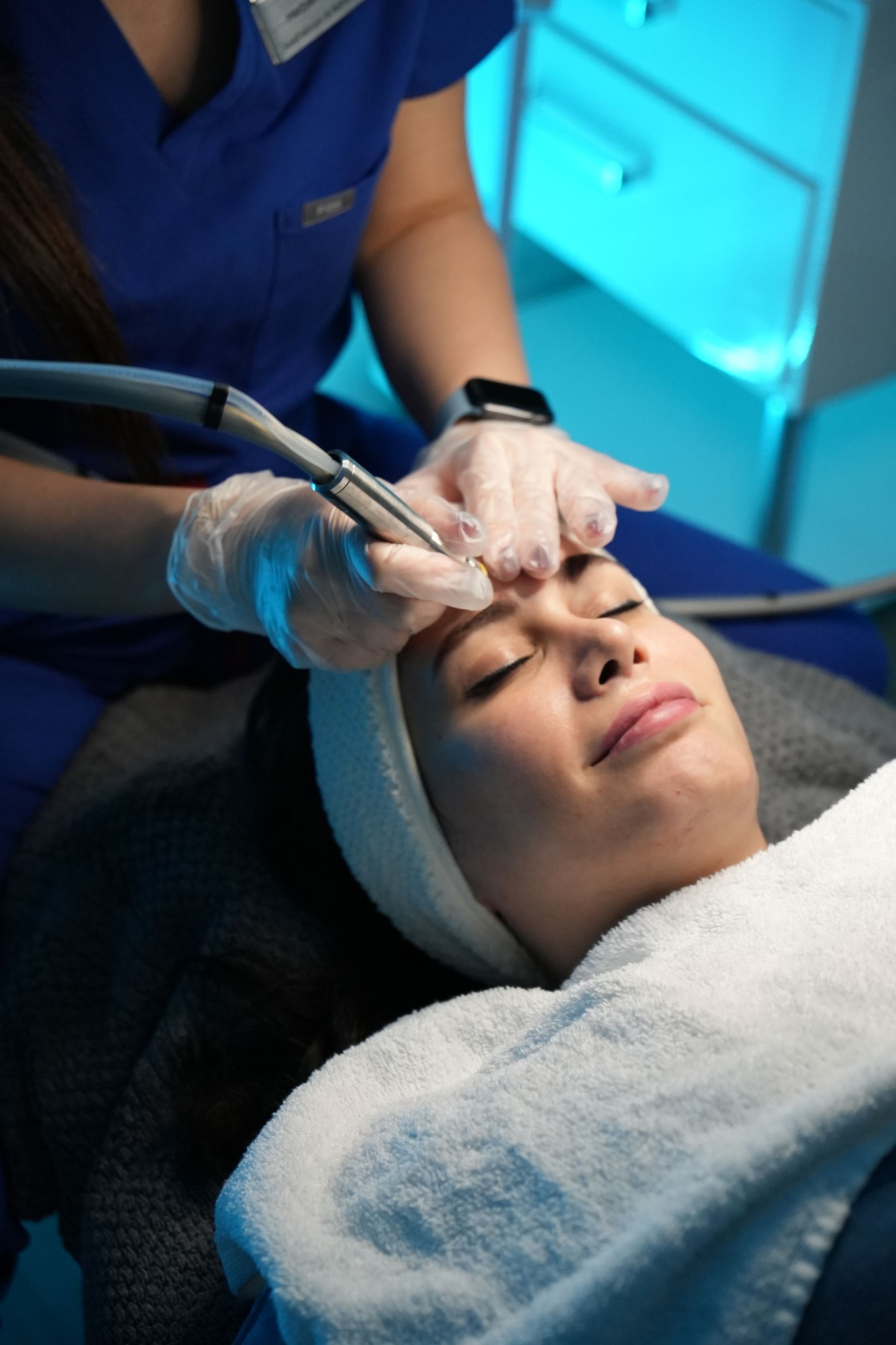 A woman is getting a facial treatment at a beauty salon.